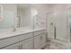 Modern bathroom with double vanity, quartz countertop, and glass-enclosed shower at 654 Saddlebred Ln, Locust, NC 28097