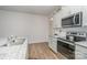 Bright kitchen with gray cabinets, stainless appliances, granite counters, and hardwood flooring at 654 Saddlebred Ln, Locust, NC 28097