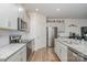 Modern kitchen features stainless steel appliances, gray cabinets, granite counters, and wood floors at 654 Saddlebred Ln, Locust, NC 28097