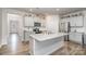 Well-lit kitchen with gray cabinets, stainless appliances, granite countertops, and a spacious island at 654 Saddlebred Ln, Locust, NC 28097