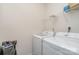 Bright laundry room with white washer and dryer units and shelving for storage at 654 Saddlebred Ln, Locust, NC 28097