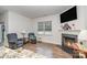 Cozy living room featuring a fireplace, hardwood floors, and plenty of natural light at 654 Saddlebred Ln, Locust, NC 28097