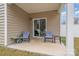 Covered patio featuring two rocking chairs and a sliding glass door to the home's interior at 654 Saddlebred Ln, Locust, NC 28097