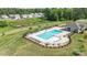 Aerial view of a neighborhood pool and amenity center surrounded by lush landscaping at 654 Saddlebred Ln, Locust, NC 28097