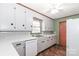 Galley style kitchen with white cabinets and appliances at 105 Kiser Ln, Statesville, NC 28677