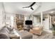 Living room with stone fireplace, sectional sofa, and large TV at 11800 Five Cedars Rd, Charlotte, NC 28226