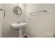 Charming powder room features pedestal sink, hardwood floors, and neutral paint at 13929 Tilesford Ln, Huntersville, NC 28078