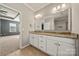 This bathroom features double sinks, granite countertops, and tile floors at 13929 Tilesford Ln, Huntersville, NC 28078