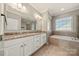 Bathroom featuring double sinks, granite countertops, garden tub, and shower at 13929 Tilesford Ln, Huntersville, NC 28078