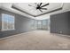 Spacious bedroom with large windows, tray ceiling, and neutral tones, creating a serene and inviting atmosphere at 13929 Tilesford Ln, Huntersville, NC 28078