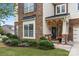 Beautiful home with a stone and siding exterior, a covered porch, and mature landscaping at 13929 Tilesford Ln, Huntersville, NC 28078