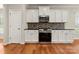 Well-designed kitchen with white cabinets, built-in microwave, and gas range at 13929 Tilesford Ln, Huntersville, NC 28078