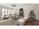 Cozy living room featuring a stone fireplace and comfortable seating arrangement at 13929 Tilesford Ln, Huntersville, NC 28078