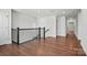 Open second floor hallway with hardwood floors, black iron railing, and natural light at 2237 Millennium Dr # 012, Lancaster, SC 29720