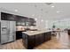 Modern kitchen featuring dark cabinets, stainless steel appliances, and a large granite island with pendant lighting at 208 Waterlynn Ridge Rd # B, Mooresville, NC 28117