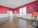 Living room with red walls, hardwood floors and mirror at 154 W End St, Chester, SC 29706