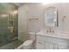 Stylish bathroom with glass enclosed shower, tile, gold fixtures and arched mirror at 407 Crepe Myrtle Ln, Weddington, NC 28104