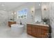 This primary bath features double vanities, white marble tile, soaking tub, and a view to the outdoors at 407 Crepe Myrtle Ln, Weddington, NC 28104