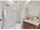 The bathroom has a glass shower, modern fixtures, and a wood vanity with white basin at 407 Crepe Myrtle Ln, Weddington, NC 28104