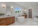 This bright primary bath features double vanities, white marble tile, and a soaking tub at 407 Crepe Myrtle Ln, Weddington, NC 28104