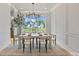 Elegant dining room featuring paneled walls, a modern chandelier, and a large window view at 407 Crepe Myrtle Ln, Weddington, NC 28104