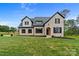 Beautiful two-story brick home features a manicured lawn and an elegant arched doorway at 407 Crepe Myrtle Ln, Weddington, NC 28104
