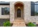 Elegant brick entryway with an arched doorway, wood door, and lantern-style lighting at 407 Crepe Myrtle Ln, Weddington, NC 28104