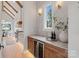 Features a wine cooler, cabinets, and marble countertops with a view to the adjacent kitchen at 407 Crepe Myrtle Ln, Weddington, NC 28104