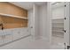 The mudroom features built in shelving, wood accent wall, and access to a walk-in pantry at 407 Crepe Myrtle Ln, Weddington, NC 28104