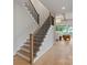 Bright, modern staircase with wood and black metal railing, and an open view to the living room at 407 Crepe Myrtle Ln, Weddington, NC 28104