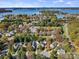 Aerial view of neighborhood homes with community buildings and lake in the distance at 8225 Ballymore Ct, Huntersville, NC 28078