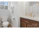 Bathroom with modern gold fixtures, wood cabinets, and a white countertop at 8225 Ballymore Ct, Huntersville, NC 28078