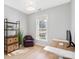 Bright bedroom with a wicker light, wood floors, a desk, chair, and shelving unit at 8225 Ballymore Ct, Huntersville, NC 28078