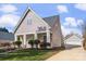 Charming home featuring light gray siding, stylish front door, white columns, and detached garage at 8225 Ballymore Ct, Huntersville, NC 28078