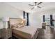 Spacious main bedroom with dark hardwood floors, a ceiling fan, and large windows dressed in blue drapes at 8225 Ballymore Ct, Huntersville, NC 28078