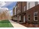 Townhomes with brick and white siding, grassy areas, and walkway at 2212 Noble Townes Way, Charlotte, NC 28262