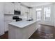 Modern kitchen with white cabinets, island, and stainless steel appliances at 2212 Noble Townes Way, Charlotte, NC 28262