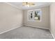 Neutral bedroom featuring fresh carpet, a ceiling fan, and a large sunny window at 27 Sw Barbee Rd, Concord, NC 28027