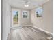 Sunlit bonus room featuring laminate flooring, a ceiling fan, and access to back yard at 27 Sw Barbee Rd, Concord, NC 28027