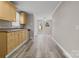 Open kitchen with natural wood cabinets, views to the back, and access to bonus room at 27 Sw Barbee Rd, Concord, NC 28027