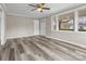 Light-filled living room with laminate flooring, multiple large windows, and fresh paint at 27 Sw Barbee Rd, Concord, NC 28027