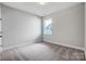 Neutral bedroom with soft carpet and large window with natural light at 4021 Grace Pointe Dr # 104, Wesley Chapel, NC 28079