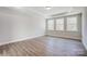 Sunlit bedroom featuring a tray ceiling and three large windows at 4021 Grace Pointe Dr # 104, Wesley Chapel, NC 28079