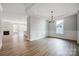 Dining room featuring hardwood floors, traditional millwork, modern light fixture, and ample natural light at 4021 Grace Pointe Dr # 104, Wesley Chapel, NC 28079