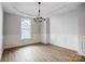 A stylish dining room with hardwood floors, traditional wainscoting, and a unique light fixture at 4021 Grace Pointe Dr # 104, Wesley Chapel, NC 28079