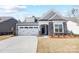 Charming single-Gathering home featuring stone accents, a two-car garage, and a well-manicured lawn at 4021 Grace Pointe Dr # 104, Wesley Chapel, NC 28079