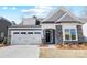 Charming single-Gathering home featuring stone accents, a two-car garage, and a well-manicured lawn at 4021 Grace Pointe Dr # 104, Wesley Chapel, NC 28079