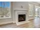 Cozy fireplace with white mantle, flanked by natural light from large windows and sliding glass doors at 4021 Grace Pointe Dr # 104, Wesley Chapel, NC 28079