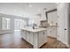 Spacious kitchen with stainless steel appliances, large island, and hardwood floors that lead to an outdoor view at 4021 Grace Pointe Dr # 104, Wesley Chapel, NC 28079