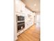 Modern kitchen with stainless steel appliances, white cabinetry, and hardwood flooring at 7928 Cedarsmith Ct, Charlotte, NC 28217